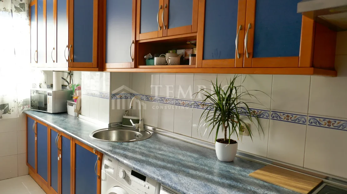Una cocina espaciosa con electrodomésticos de acero inoxidable y encimeras de granito.