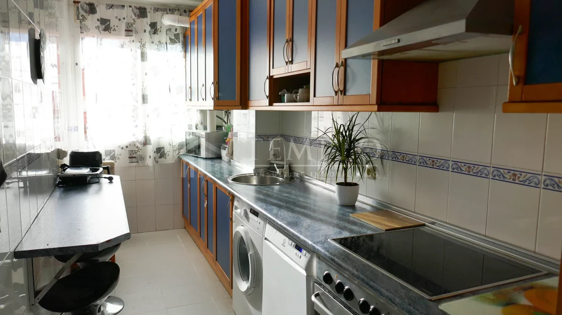 Una cocina espaciosa con electrodomésticos de acero inoxidable y encimeras de granito.